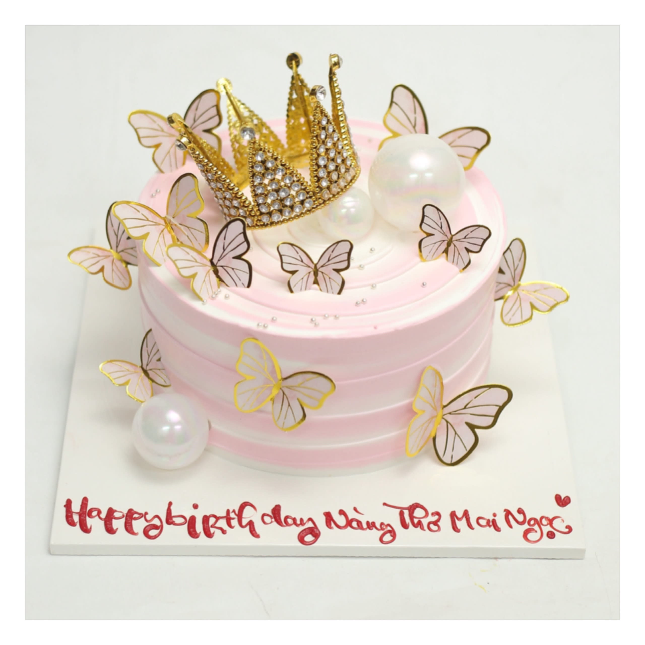 Bánh kem màu hồng pastel đính vương miện bướm
