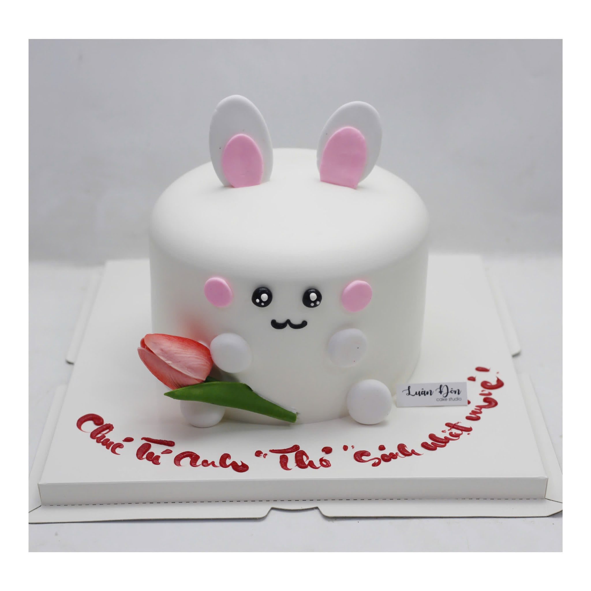Bánh kem thỏ trắng cầm hoa tulip đỏ